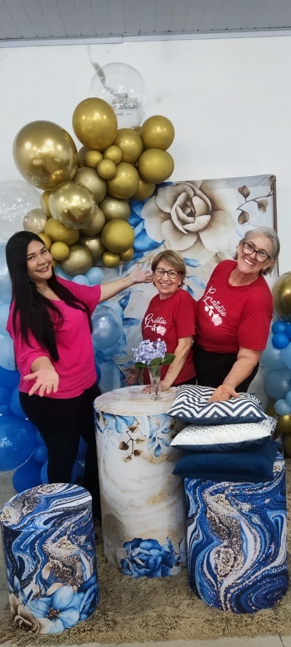 Participantes posando no cantinho decorado com balões e flores